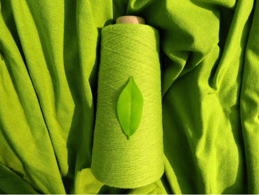 yarn lying on a green woven fabric